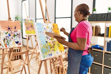 Senior african american woman on back view drawing at art studio