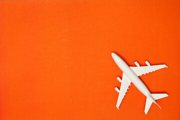 Airplane model. White plane on orange background. Travel vacation concept. Summer background. Flat...
