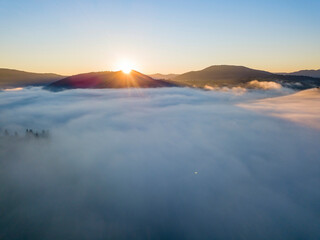 Sunrise over the fog in the Ukrainian Carpathians. Aerial drone view.