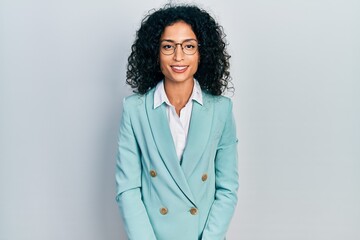 Young latin girl wearing business clothes and glasses with a happy and cool smile on face. lucky...