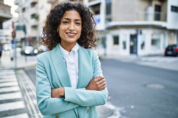 Young hispanic business woman wearing professional look smiling confident at the city