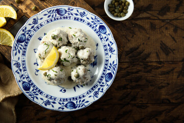 Traditional homemade meatballs with cream, capers and lemon