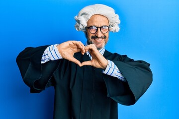 Middle age hispanic man wearing judge uniform smiling in love doing heart symbol shape with hands....
