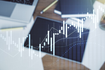 Double exposure of abstract creative financial chart and digital tablet on background, top view, research and strategy concept