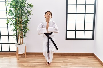 Young hispanic girl wearing karate kimono and black belt begging and praying with hands together with hope expression on face very emotional and worried. begging. © Krakenimages.com