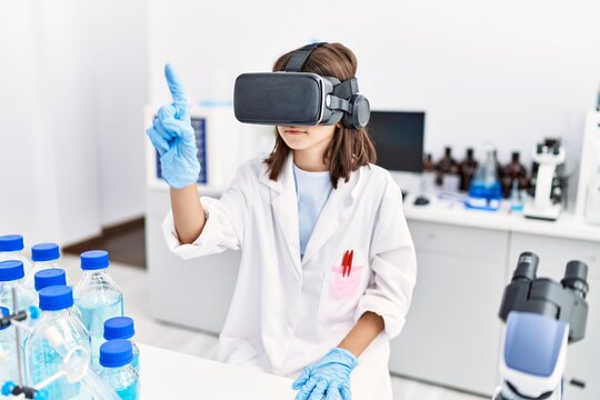 Young hispanic girl wearing virtual reality glasses at laboratory