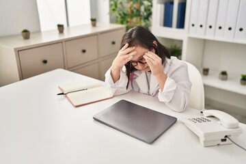 Down syndrome woman wearing doctor uniform stressed working at clinic
