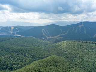 Fototapeta premium Green mountains of Ukrainian Carpathians in summer. Sunny day, rare clouds. Aerial drone view.