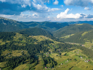 Green mountains of Ukrainian Carpathians in summer. Sunny day, rare clouds. Aerial drone view.