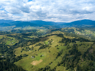 Green mountains of Ukrainian Carpathians in summer. Coniferous trees on the slopes. Aerial drone view.