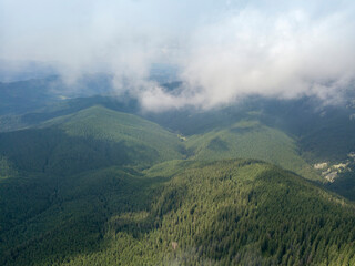 Green mountains of Ukrainian Carpathians in summer. Sunny day, rare clouds. Aerial drone view.