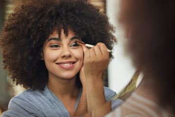 Modern life for a modern girl to lead. Shot of a beautiful woman looking in the mirror while applying makeup at home.