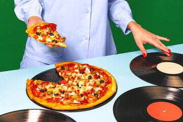 Food pop art photography. Female hands with italian pizza lying on vinyl discs on light tablecloth...