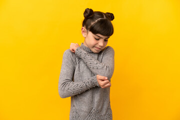Little caucasian girl isolated on yellow background with pain in elbow