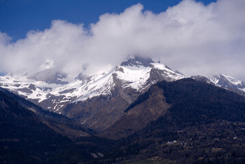 Aerial view from hill of City of Sion over the beautiful landscape of Canton Valais with the Swiss Alps on a blue cloudy spring day. Photo taken April 4th, 2022, Sion, Switzerland.
