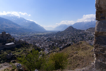 Fototapeta premium Aerial view with beautiful medieval catholic church and castle Basilique de Valère (Valeria) on a hill at City of Sion on a sunny spring day. Photo taken April 4th, 2022, Sion, Switzerland.