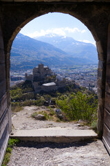 Fototapeta na wymiar Beautiful view through stone arch of ruins of medieval Tourbillon Castle on a hill at City of Sion on a sunny spring day. Photo taken April 4th, 2022, Sion, Switzerland.