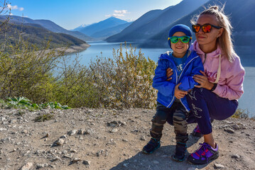 A young girl and a little boy on the background of the landscape of the Zhinvali reservoir. Georgia 2019.