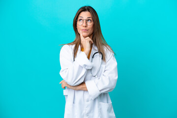 Middle age woman isolated on blue background wearing a doctor gown and thinking