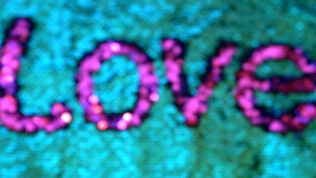 The inscription on the love jacket made with sequins flickers in different shades of pink. The shimmering, pink inscription is love.