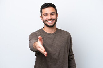 Young Brazilian man isolated on white background shaking hands for closing a good deal