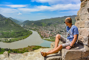 A man on the background of a view of the Mtkvari River flowing into the Aragvi. Mtskheta Georgia 2019 © Виктория Балобанова