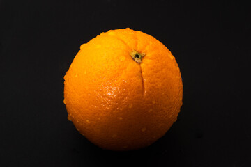 A close-up shot of a delicious fresh orange with a dark background