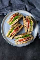 sandwich with ham cheese tomatoes lettuce onions on plate. Classic club sandwich with whole grain bread