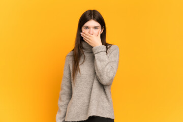 Young Ukrainian girl isolated on yellow background covering mouth with hand