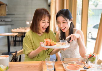 Happy girlfriends having lunch together at  restaurant