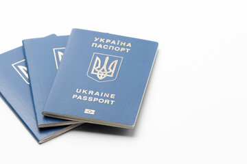 several passports of the citizen of Ukraine with a coat of arms on a wrapper lying on a white background