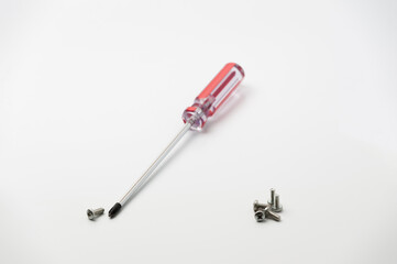 chrome screwdriver and several screws on a white background