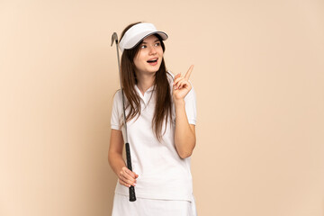 Young Ukrainian golfer girl isolated on beige background intending to realizes the solution while lifting a finger up