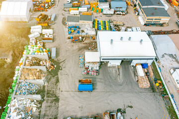 Top view of a landfill with various waste. Many dumpsters and garbage trucks sorting and recycling garbage in the industrial areas of the city