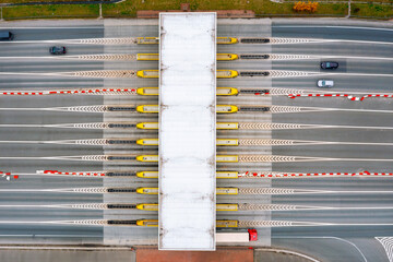 View from a height of the checkpoint. Cars pass through an automatic toll booth on a toll road in...
