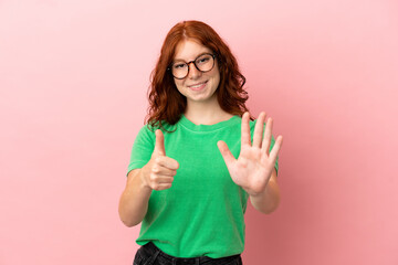 Teenager redhead girl over isolated pink background counting six with fingers