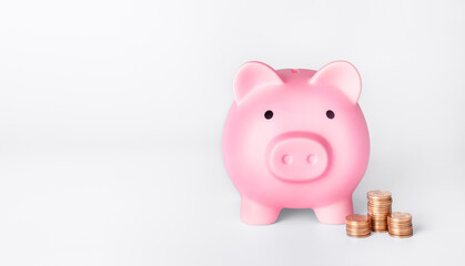 Pink piggy bank and stacks of coins. Money saving concept.