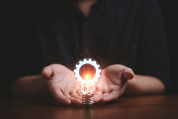 Hand holding and giving glowing lightbulb with mechanical gear for creative thinking idea and...