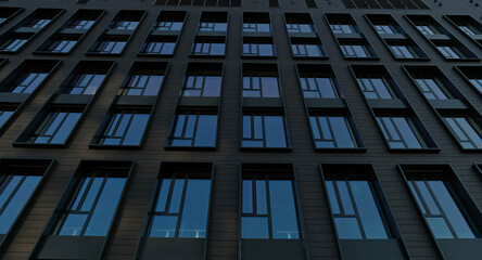 Exterior of modern dark house object. Architectural detail of a skyscraper, close-up on the windows. Real estate, residential apartments and offices. Living apartments or office building architecture.