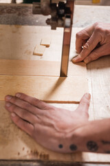 cropped view of joiner cutting plywood with band saw.
