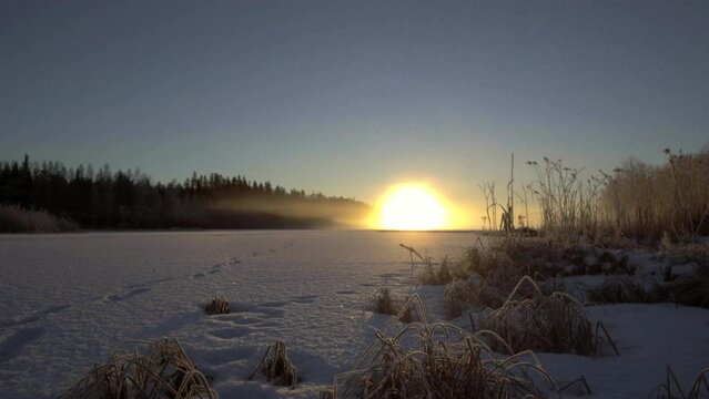Time lapse of winter Nordic sunset on frozen lake. Northern Finland