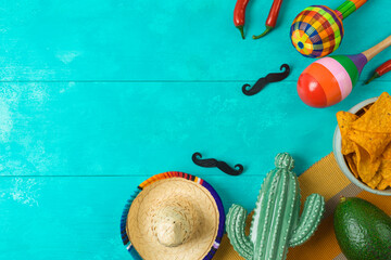 Cinco de Mayo holiday background with Mexican cactus, nachos chips, maracas and party sombrero hat. Top view, flat lay