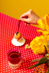 Closeup. Cropped portrait of woman tasting egg, fruit on red tablecloth over blue background....