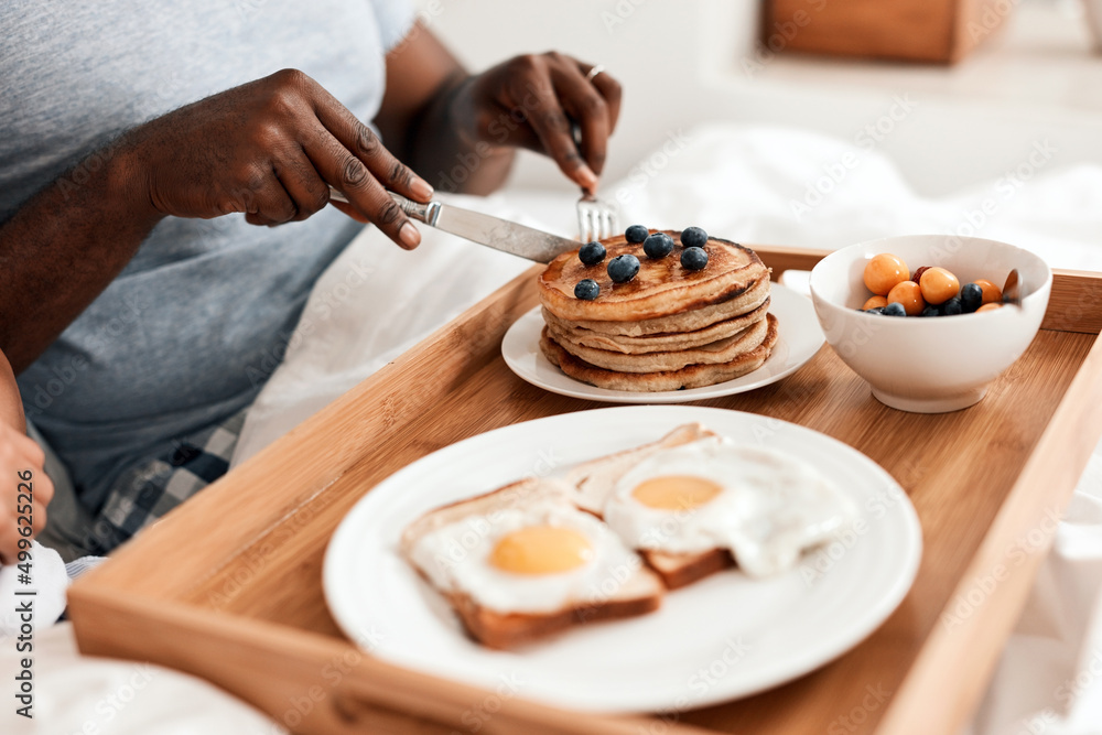 Wall mural Everything youll need to start the day with right. Shot of an unrecognizable couple enjoying breakfast in bed together at home during the day.