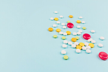 Colorful pills on a pastel blue background. Flat lay, top view, overhead, mockup, template. Pharmacy and medical concept