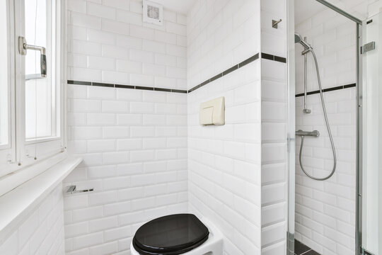 Bathroom with shower area and toilet with a window in front of it