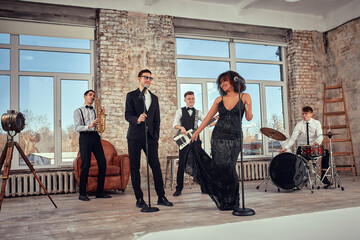 Repetition of multi ethnic jazz band in loft. Bass guitar player, electric guitar player, saxophonist and drummer at loft. Jazz music and jam session concept. passion for music and youth culture