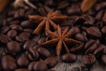 chocolate, cinnamon sticks  and coffee beans on wooden background