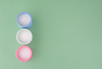 Green Background with pink, green and blue candles  for SPA. View above. Space for text.  