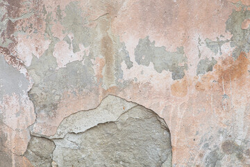 Old flaky wall with destroyed plaster. Renovation of old house. Industrial style design wall background. Grunge cracked concrete wall with old paint. Shabby peeling old background
